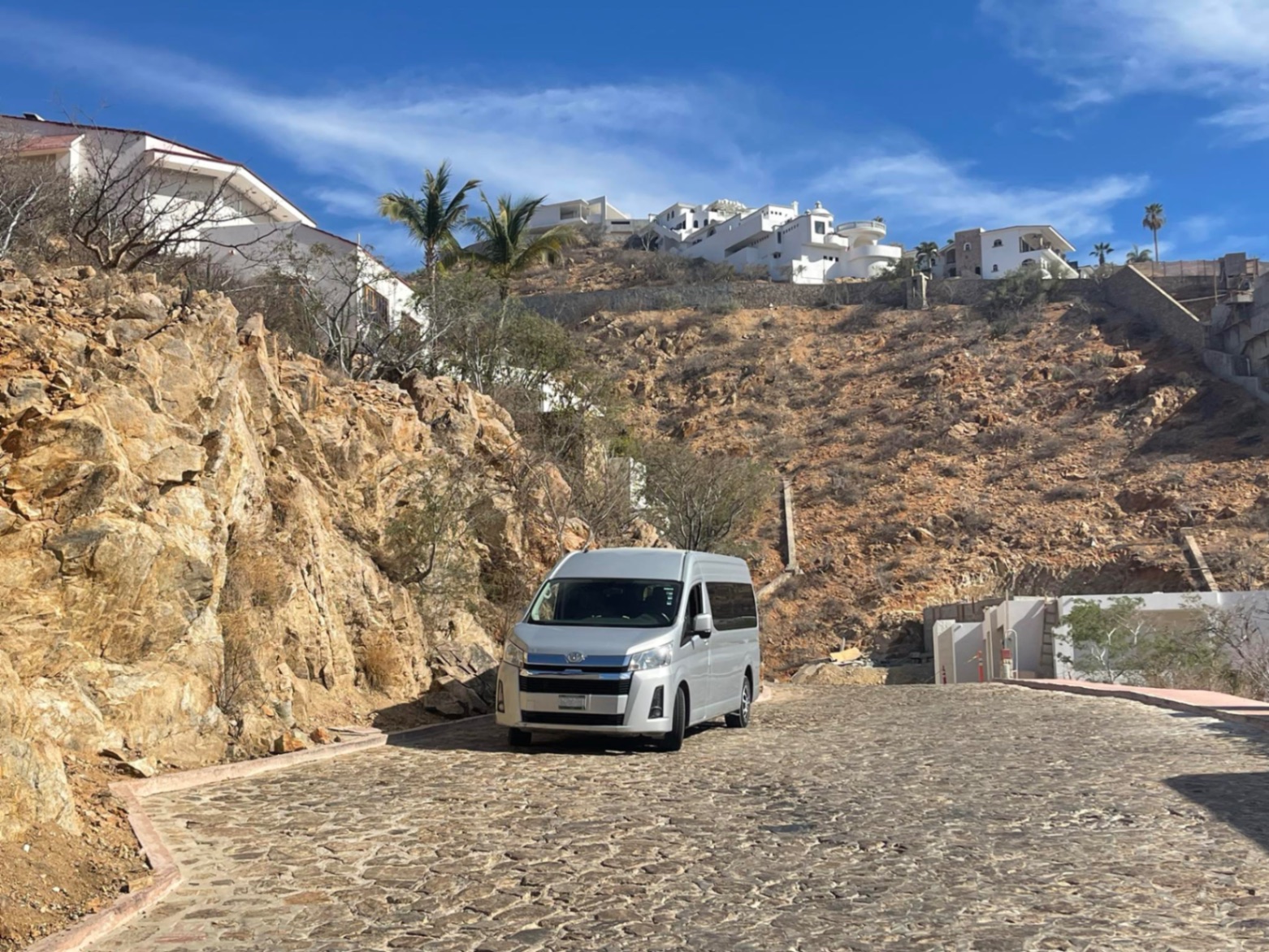 Van climbing a Cabo hillside villa road